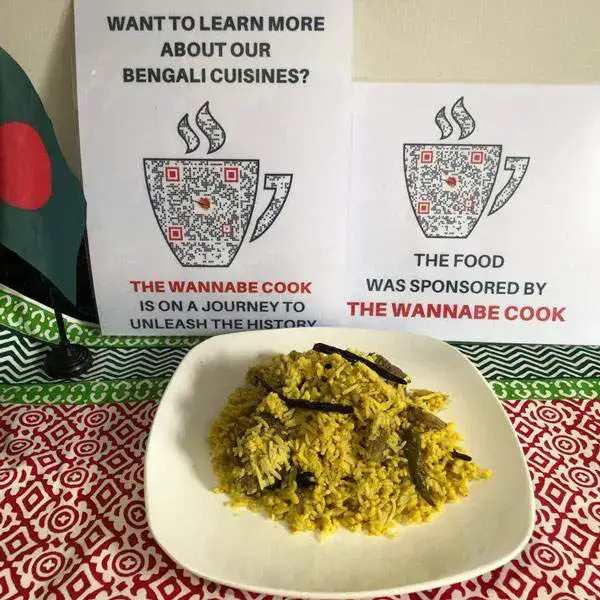 Plate of yellow rice in front of The Wannabe Cook cultural-day display signs.